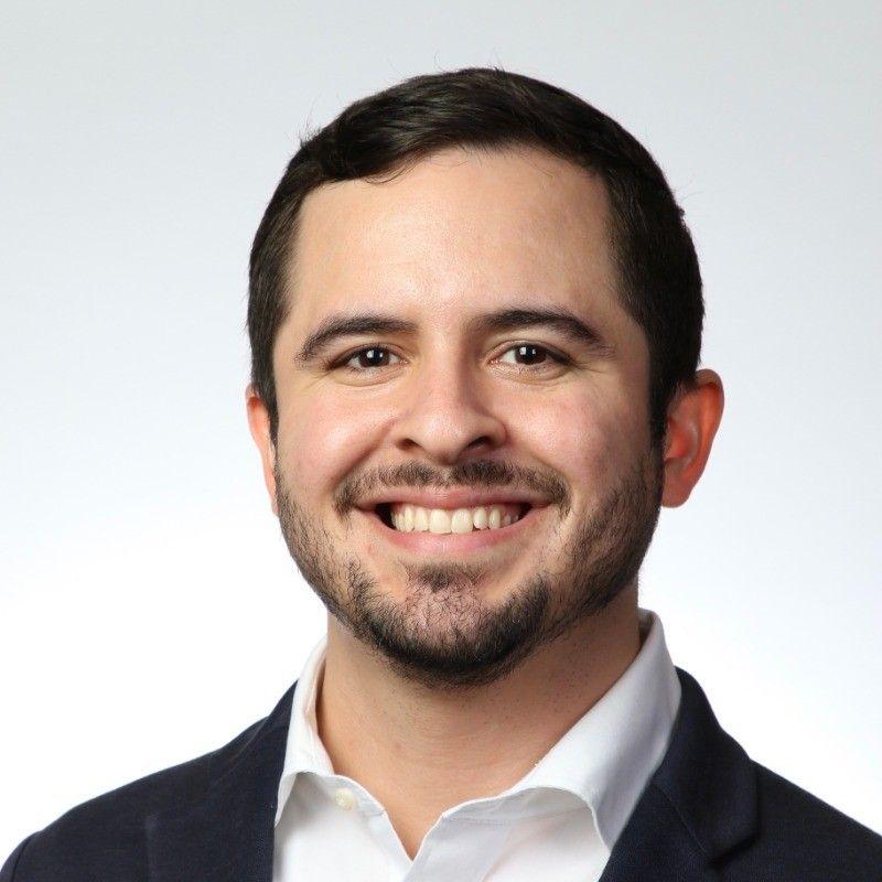 Carlos Medina in a dark blazer and white shirt